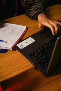a person typing on a laptop on a wooden table